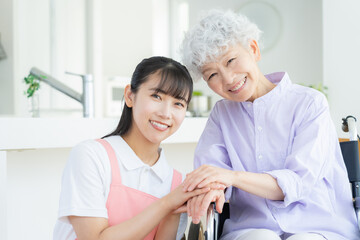リビングで介護をする若い女性介護士