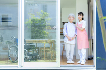 Fototapeta premium リビングで介護をする若い女性介護士