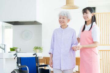リビングで介護をする若い女性介護士