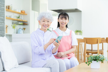 リビングで介護をする若い女性介護士