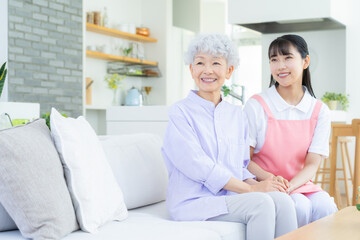 リビングで介護をする若い女性介護士