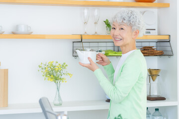 キッチンで家事をするシニアの女性 © dimlight