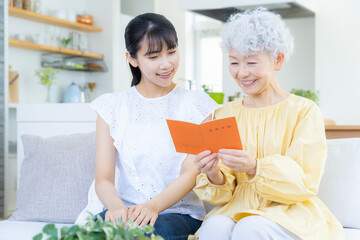 リビングで年金手帳を見る祖母と孫