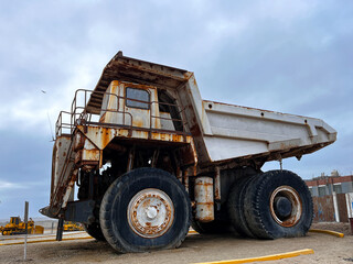 Large grey old quarry dump truck. Big green rusty mining truck out of work standing for exhibition on the coast of Peru in San Juan de Marcona. Mining truck