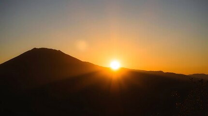 Sunrise silhouettes mountain range in gold