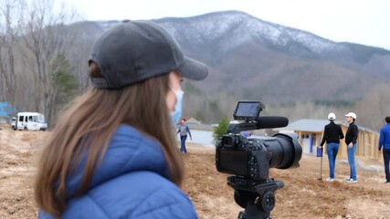 Capturing the Moment: A dedicated professional focuses on capturing the perfect shot of a construction site, showcasing the blend of human effort and the majestic backdrop of nature's beauty.