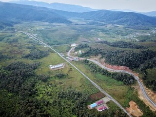 Aerial view of a small town in the Arfak Mountains. A small town in summer. Settlements, hills, and...