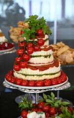 Caprese, Gourmet Cheese with Dried Tomatoes and Fresh Herbs, Elegant Appetizer on Silver Tray, Cheese Platter with Cherry Tomatoes and Basil, top view	