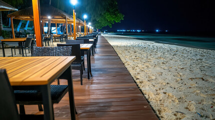 Fototapeta premium Serene Beachside Dining Under Stars with Wooden Pathway and Trees at Night, Peaceful Coastal Ambiance for Relaxation and Enjoyment