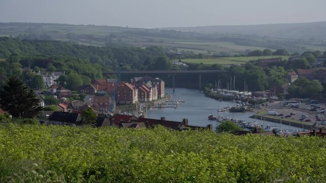 Panoramic view of Whitby harbor with boats and bridge connecting the two sides of the river Esk in North York Moors National Park, United Kingdom