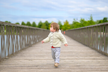 Toddler Walking On Wooden Bridge