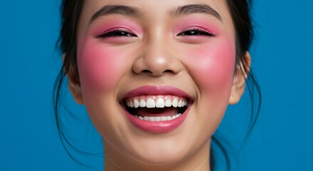 Woman smiling broadly against blue background