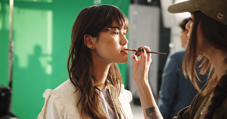 Set, women and makeup artist with brush, creative and application of cosmetics, preparation or...