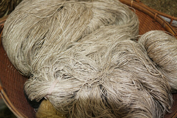 Large, rustic bundles of natural hemp fiber, showcasing their earthy tones and coarse texture, are meticulously prepared for traditional hand-weaving and textile production.