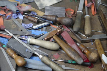 Pile of tools including a variety of knives and scissors