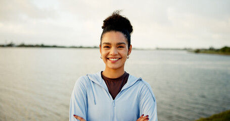 Fitness, lake and portrait with woman outdoor in nature for cardio, running or training routine. Arms crossed, exercise and smile of runner or sports athlete in park for improvement or workout