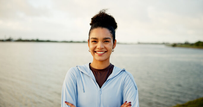 Fitness, lake and portrait with woman outdoor in nature for cardio, running or training routine. Arms crossed, exercise and smile of runner or sports athlete in park for improvement or workout