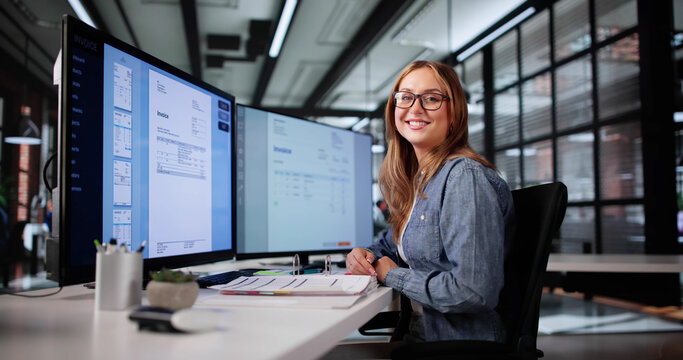 Professional Woman Analyzing Invoices On Computer Screen