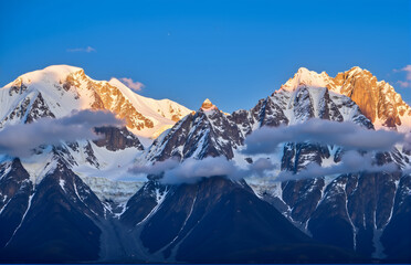 Fototapeta premium Snow Mountains, Clouds & Sunlit Golden Peaks