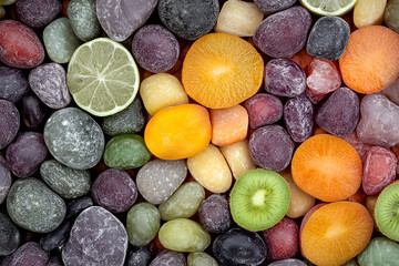 Colorful fruit and stone arrangement offers a vibrant, textured composition with citrus, kiwi and carrot slices set among various smoothed rocks.