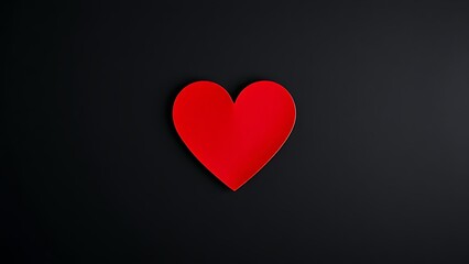 Minimalist red heart on dark textured background with directional lighting