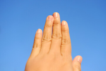 Close up finger of woman hand on blue sky 