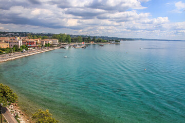 A picturesque coastal town on Lake Garda with turquoise waters and a marina.