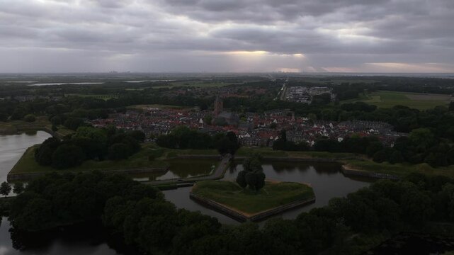 Aerial dusk view of fortified star-shaped moat and a village under dramatic sky in Solingen, Germany