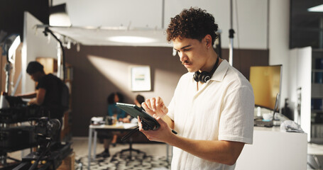 Man, producer and tablet for filming backstage for editing video, review script and shooting...
