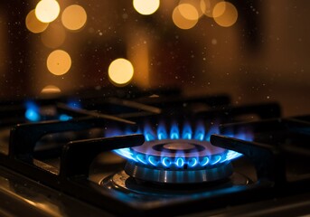 The essence of home cooking captured: a vivid blue gas flame heating a kitchen burner at night.

