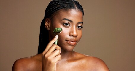 Beauty, skincare and girl with jade roller in studio for depuffing, facial massage and skin glow....