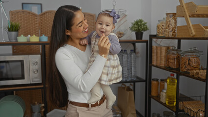 Woman holding baby girl in living room showcasing love and family in a cozy home environment with indoor decor emphasizing warmth and care.