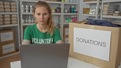 Focused woman uses laptop for typing in a warehouse surrounded by blonde young volunteer smiling...
