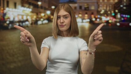 Young blonde woman crosses bare arms in x denial gesture under streetlights on crowded city street...