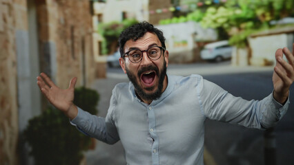 Hispanic man with beard expressing joy on sunny street backdrop, showcasing emotion in an outdoor...