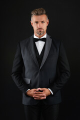 Man in rich bespoke tux. Tuxedo man in menswear isolated on black. Successful man in formal menswear. Menswear fashion. Elegant tuxedo bowtie. Rich businessman on formal event