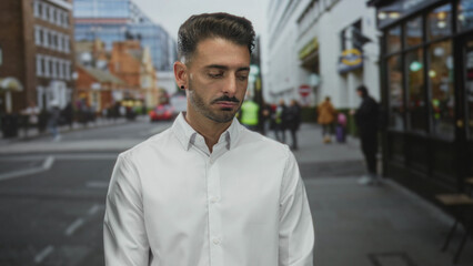 Naklejka premium Man smiling showing face on busy urban street lined with passing cars and storefront windows behind him; happiness.