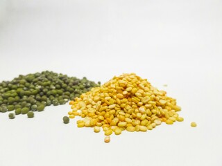 Close-up of split yellow mung beans and whole green mung beans on a white background. Perfect for food, health, and nutrition-related visuals.