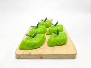 Green sticky rice cake (wajik) layered with pandan leaves, a traditional Indonesian delicacy,...