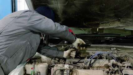 Professional mechanic troubleshooting engine issues, performing precise diagnostics with advanced tools inside well organized automotive repair facility