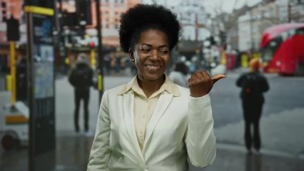 Fototapete Londoner Roter Bus African american woman in white suit gestures on a busy city street with a red bus in the background.  © Krakenimages.com