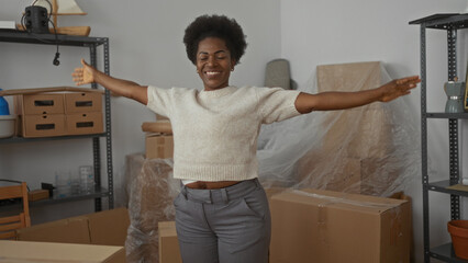 Young woman rejoicing in modern living room surrounded by unpacked boxes denotes new beginning and...
