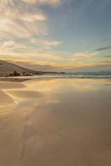 Golden light at sunrise over a rocky beach at low tide. Wylie Bay, Esperance Western Australia.