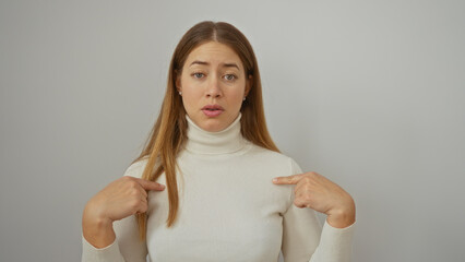 Woman pointing at herself with a confused expression isolated over a white background, wearing a...