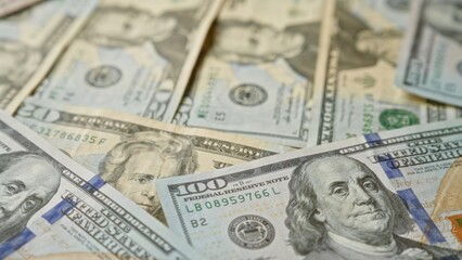 Various denominations of united states dollar banknotes scattered closely together.