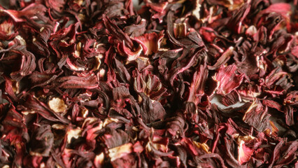 Dried hibiscus petals forming a colorful and textured background showcasing the vividness of the dried flower pieces