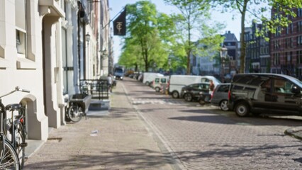 Blurred street view in amsterdam netherlands showcasing defocused cityscape with parked bicycles and vehicles under green trees on a sunny day.