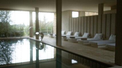 Blurred view of a serene indoor spa with sunlight streaming through windows, highlighting the calm...