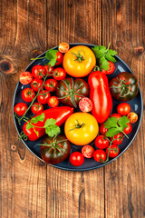 Ripe tomatoes on rustic wooden background.