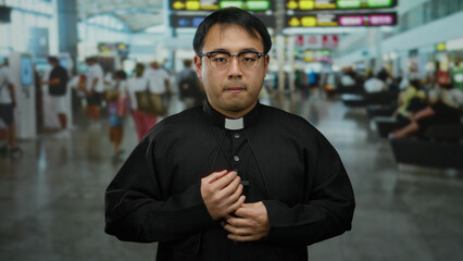 Chinese priest in a bustling airport terminal displaying a worried expression, surrounded by...